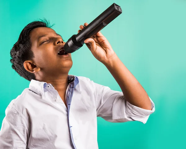 Young indian boy in white shirt yelling in microphone, little kid singing, Little indian boy with microphone sings a song, Singing asian Young boy, Cute young asian boy singing into a microphone