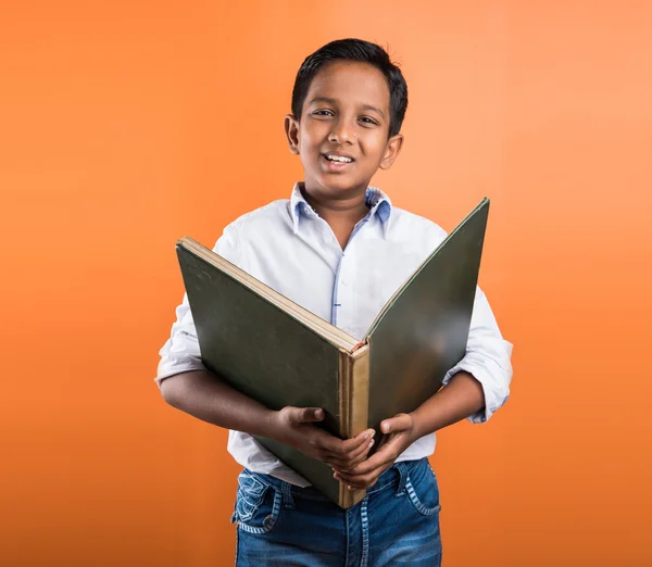 Indian kid enjoying reading book, asian kid reading book, african kid reading book, indian kid studying, indian kid holding book, portrait, indian kid standing with book, geography book, orange back