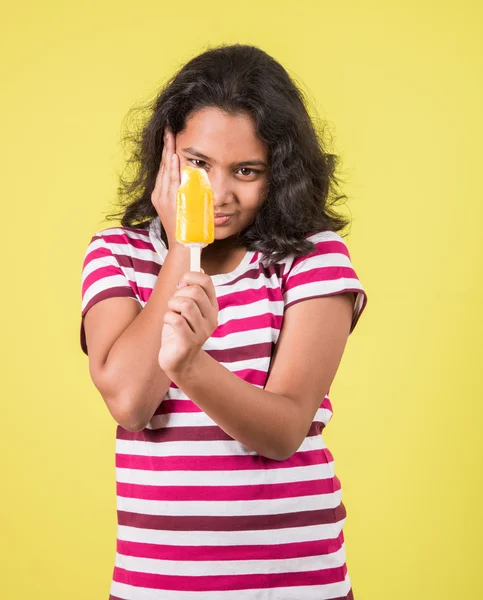 Happy Little Indian girl with an ice candy or ice cream in hand, asian girl and ice cream