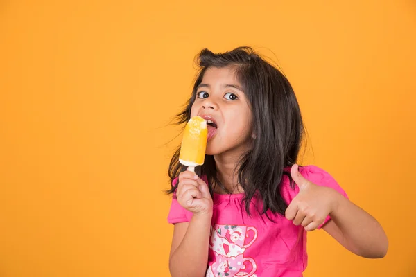 Happy Little Indian girl with an ice candy or ice cream in hand, asian girl and ice cream