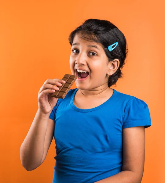 Indian small girl with chocolate, asian small girl with chocolate, indian girl eating chocolate, asian girl eating chocolate, small indian girl and chocolate, small asian girl and chocolate