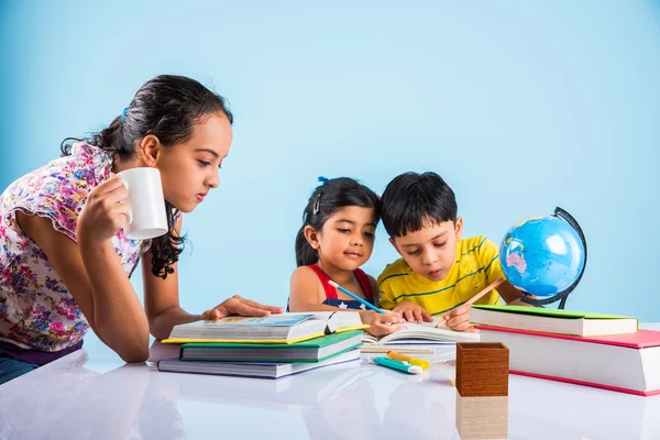 Three cute indian kids studying, smart asian girls and boy doing home work, indian siblings studying, indian small girl helping her brother and sister in doing homework