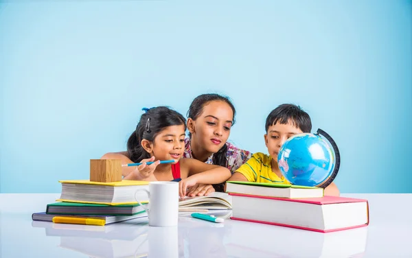 Three cute indian kids studying, smart asian girls and boy doing home work, indian siblings studying, indian small girl helping her brother and sister in doing homework