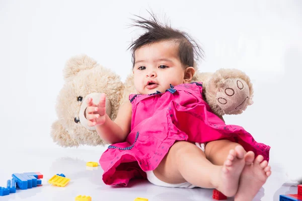 Indian baby playing with toys or blocks, asian infant playing with toys on white background, indian baby girl playing with toys, indian toddler playing with toys, indian baby girl lying on white floor