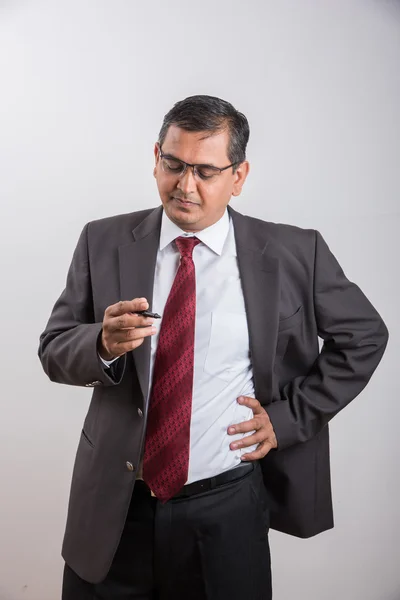 Indian businessman holding ball pen and thinking, indian businessman thinking, asian businessman holding pen while deep thinking, indian businessman solving problem, isolated over white background