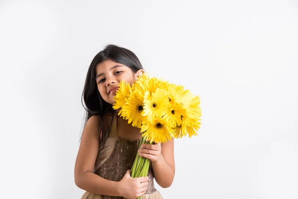 Indian small girl holding bouquet of yellow gerbera flowers, isolated over white background, indian girl and flowers, asian girl with flowers