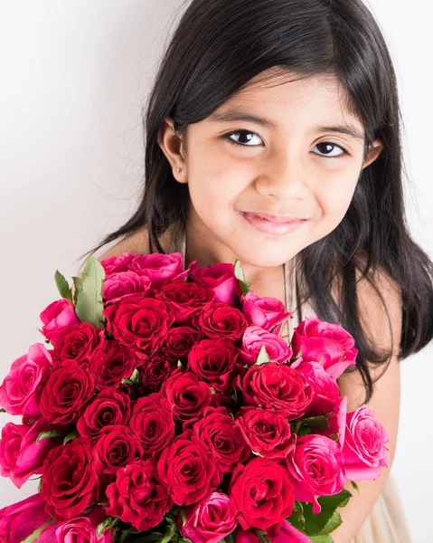 Indian little girl holding bouquet or red rose flowers, asian girl with flowers, little indian girl with bunch of red roses