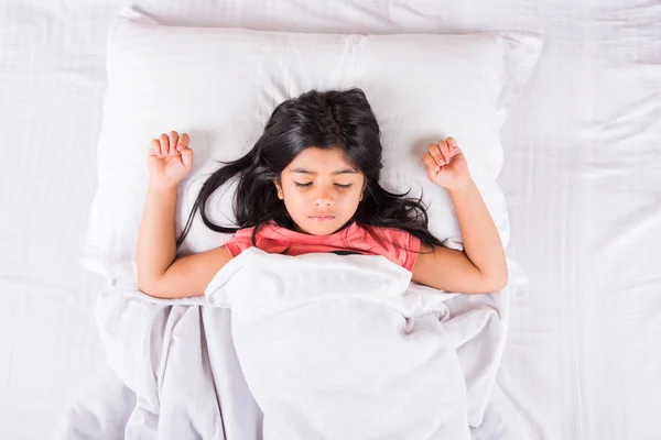 Cute Indian Girl sleeping over white pillow, small asian girl sleeping on bed