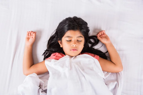 Cute Indian Girl sleeping over white pillow, small asian girl sleeping on bed