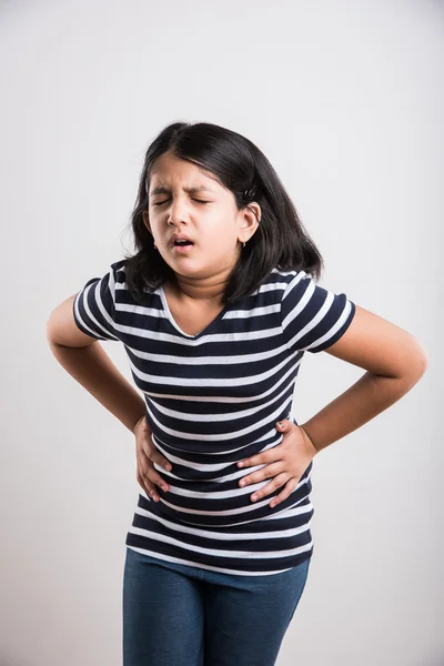 Indian small girl having stomach ache, asian girl having pain in abdomen