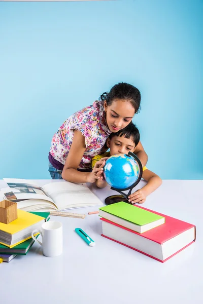 Cute indian kids studying, smart asian girl and boy doing home work, indian siblings studying, indian small girl helping her brother in doing homework