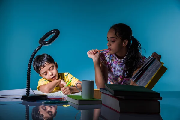 Cute indian kids studying, smart asian girl and boy doing home work, indian siblings studying, indian small girl helping her brother in doing homework