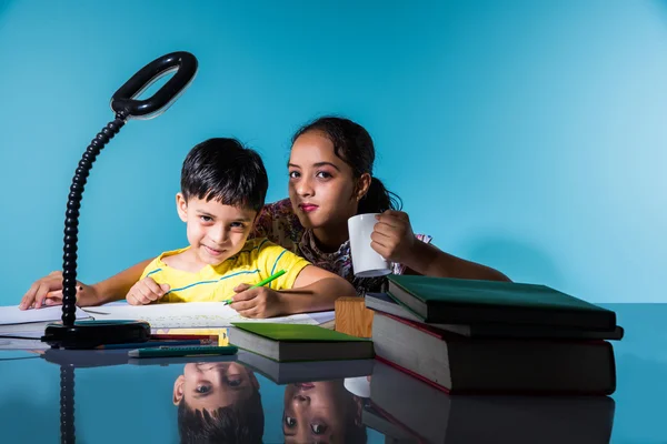 Cute indian kids studying, smart asian girl and boy doing home work, indian siblings studying, indian small girl helping her brother in doing homework