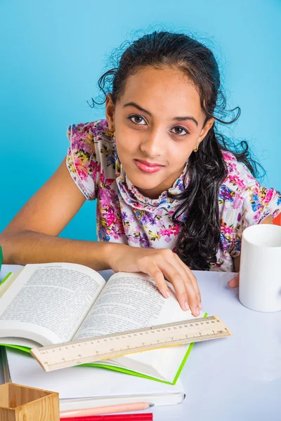 Education and home concept - stressed student girl with books, indian girl child tired of studying or doing homework, asian girl studying and stressed, with globe toy and coffee mug