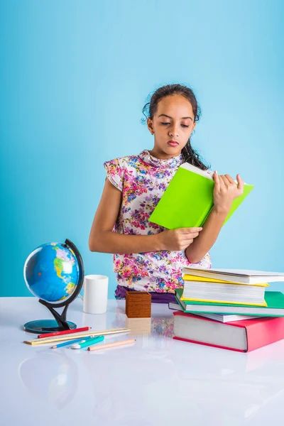 Education and home concept - stressed student girl with books, indian girl child tired of studying or doing homework, asian girl studying and stressed, with globe toy and coffee mug