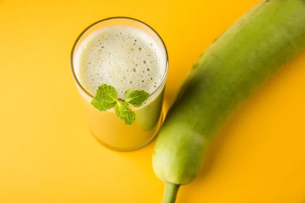 Juice of bottle gourd or lauki juice or Lagenaria siceraria juice, bottle gourd juice, powerful health juice popular in India, isolated over white background