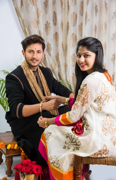 Indian sister applying tika on brother\'s forehead, enjoying and celebrating Raksha Bandhan festival