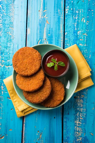 Indian chat item aloo or aalu tikki or tikiya or fried potato cake also known as ragda patties served with tomato ketchup, selective focus