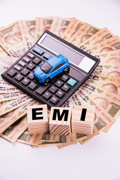 Buying home and car concept, indian currency notes, model home, keys, toy car and calculator, isolated