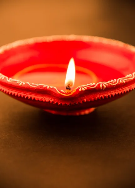 Single Clay diya lamp lit during diwali festival. happy diwali Greetings Card Design, Indian Hindu Festival of lights called Diwali