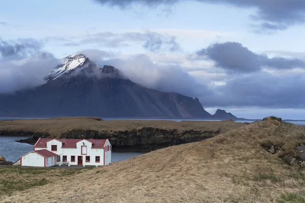 Remote white Icelandic house on the shores of Atlantic ocean