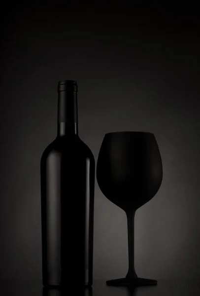 Black wine bottle and black glass of wine