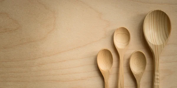 Wooden spoons of different sizes on a wooden board