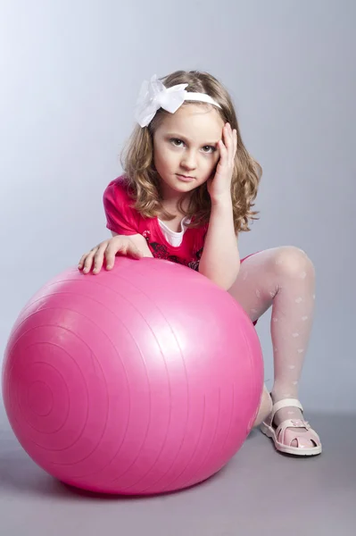 Little girl on a pink gym ball