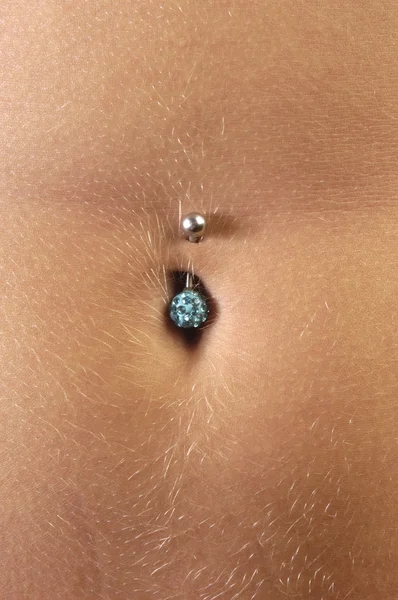 Detail of a piercing in the belly of a girl