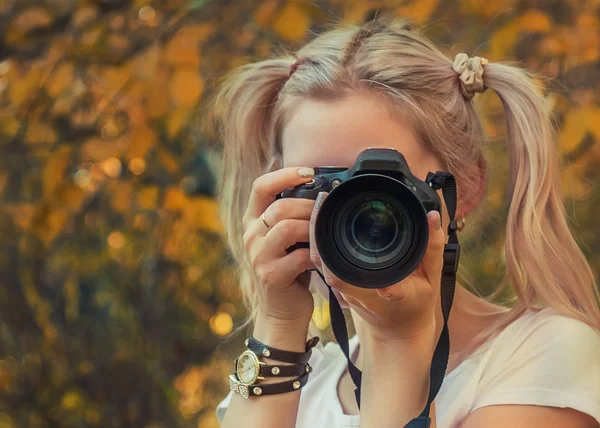 Young woman photographer taking photo outdoor