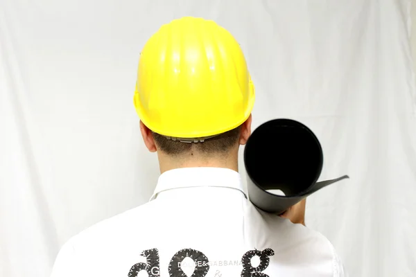 Portrait of a smiling worker in helmet holding a plan