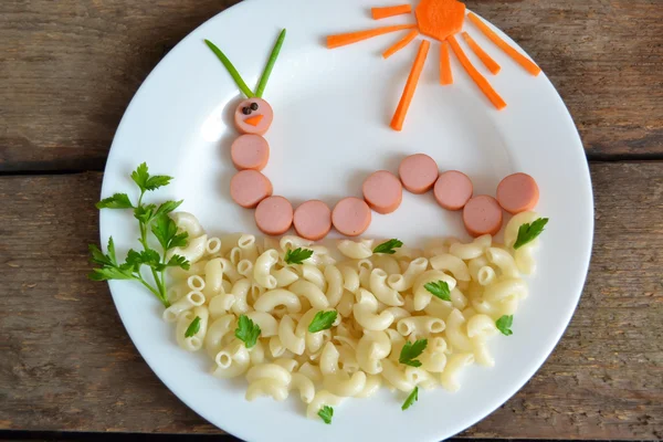 Funny caterpillar of sausages and pasta, dinner for children