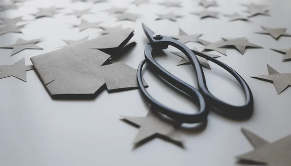 Japanese scissors and paper stars cut from kraft paper, Christmas theme, New Year theme. Minimalistic photo.