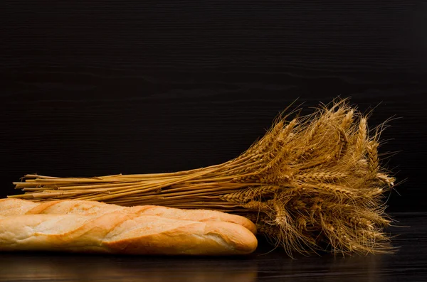 Sheaf and white loaves on a black background, with space for text