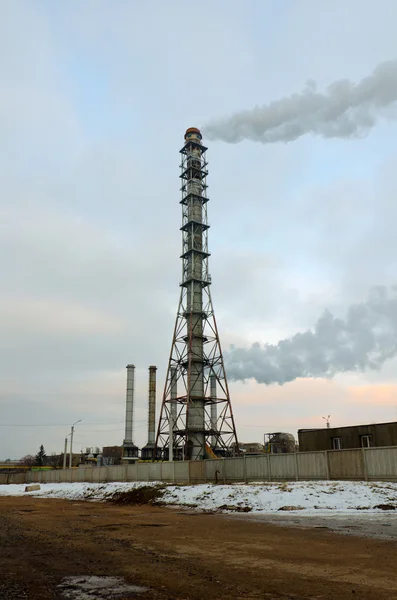 Smoking chimneys boiler on the background of the road and sunset sky