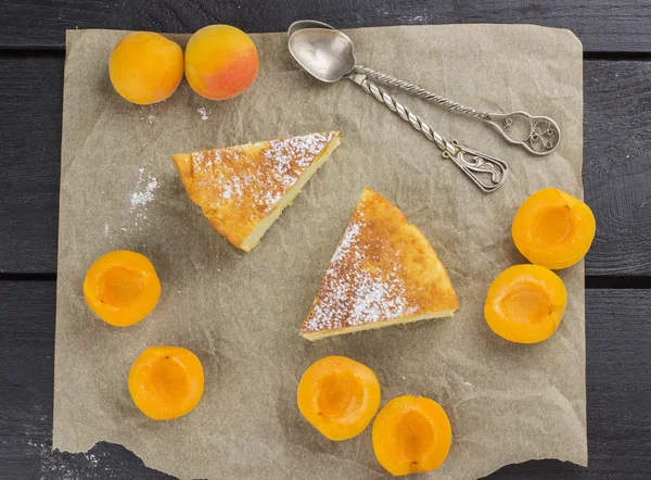 Slices of cottage cheese pie with apricots and icing sugar on a