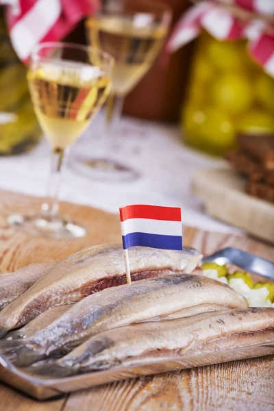 Dutch herring (\'haring\') with onions and pickles on rustic table