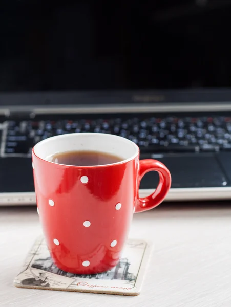 Red cup in pea on a laptop screen background