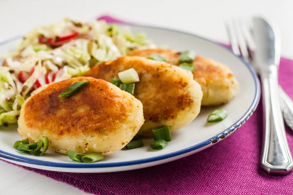 Fried potato pies with mushrooms and salad on a plate