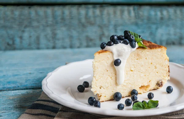 Cottage cheese baked pudding, sour cream and blueberries