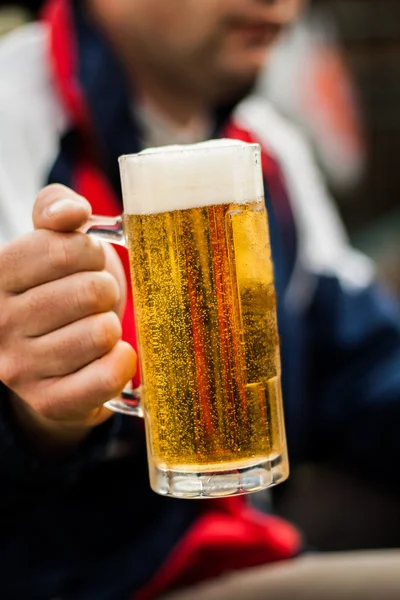 Glass of beer in his hand man close-up