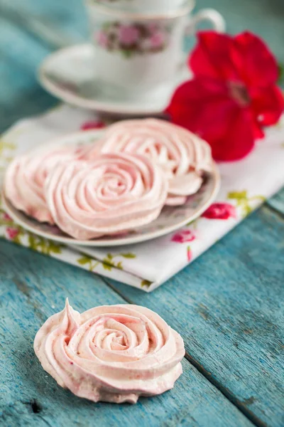 Meringue cakes in the form of roses in a romantic dish with red