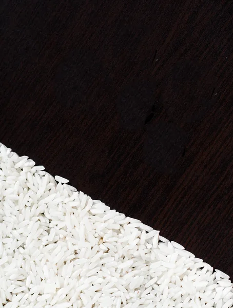 White uncooked rice on a dark background