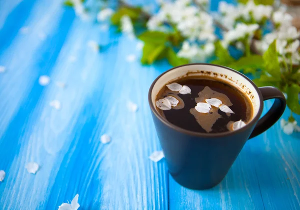 Cup of coffee on blue wood spring background with copy space