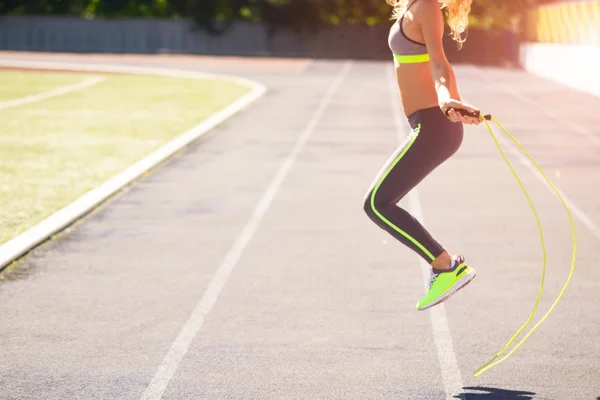 Close up of woman feet jumping, using skipping rope in stadium