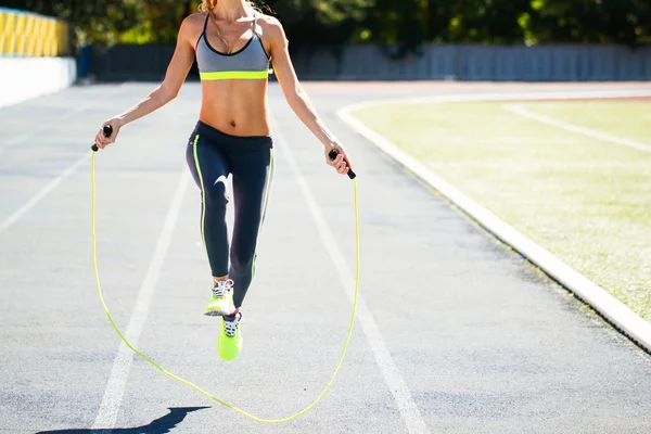 Close up of woman feet jumping, using skipping rope in stadium