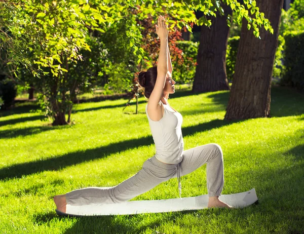 Youngl woman doing yoga in the park in the morning