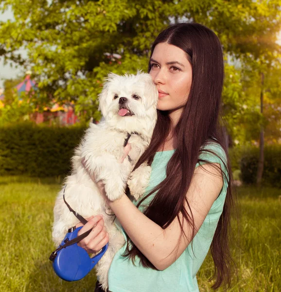 Beautiful brunette with a young dog enjoying a beautiful day