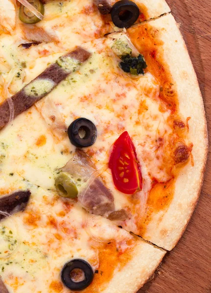 Pizza with meat, tomatoes and olives