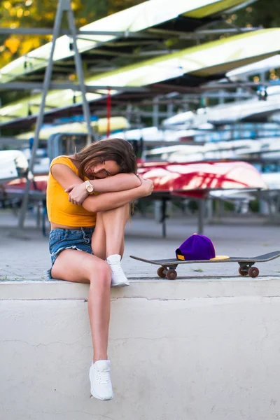 Beautiful woman in a sports park with skateboard